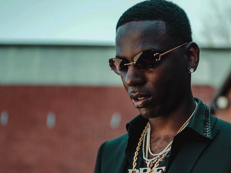 Rapper Young Dolph wearing diamond and gold chains and a black suit