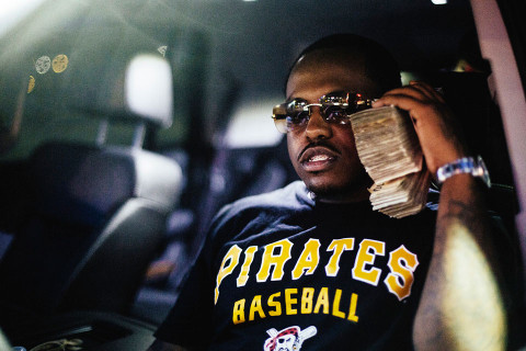 Rapper Doughboy Roc with stacks of money to his ear