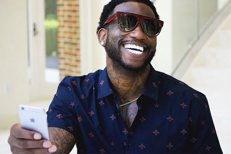 Gucci Mane smiling with an iphone