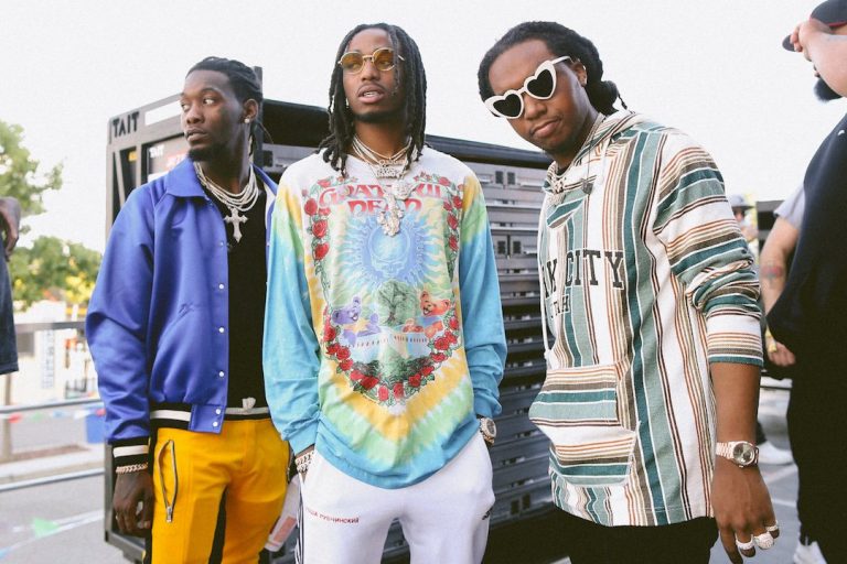 Hip hop group Migos stands outside.